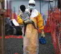 Persona con proteccion contra el virus del ebola porta un niño en brazos